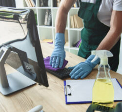 Cropped,shot,of,professional,cleaner,in,rubber,gloves,cleaning,computer
